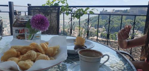 een tafel met een bord gebak en een kopje koffie bij Panoramic Vlachos in Gjirokastër