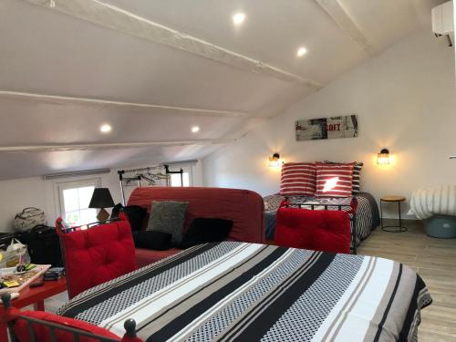 a living room with red chairs and a couch at Le Logis de Virginie - climatisé in Rochefort