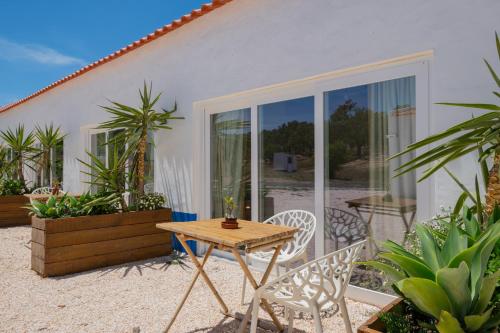 um pátio com uma mesa e cadeiras em frente a uma casa em Valle D`Água - Casas de campo em Vale de Água