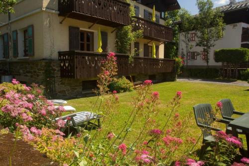 um jardim com flores cor-de-rosa em frente a uma casa em Appartement confortable a Megeve | 46m² | Vue sur montagne em Megève