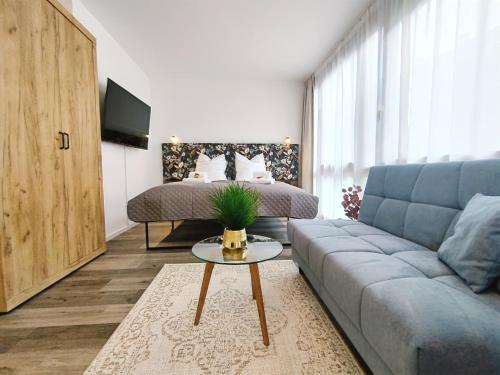 uma sala de estar com um sofá e uma cama em Design-Apartmenthaus für bis zu 12, modern, Dachterrasse, Grill, ruhige Lage, Disney plus, Wii, LAN und WLAN em Nuremberga