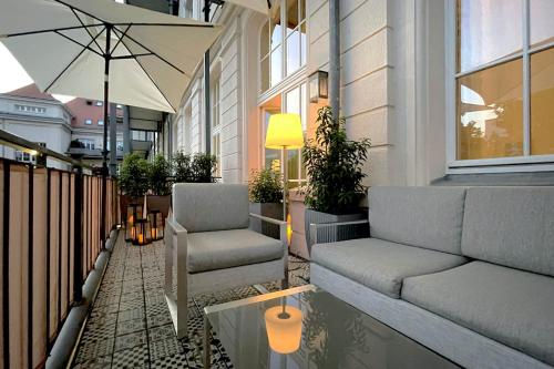 een patio met een bank, stoelen en een parasol bij Schwarzwald Loft in Baden-Baden