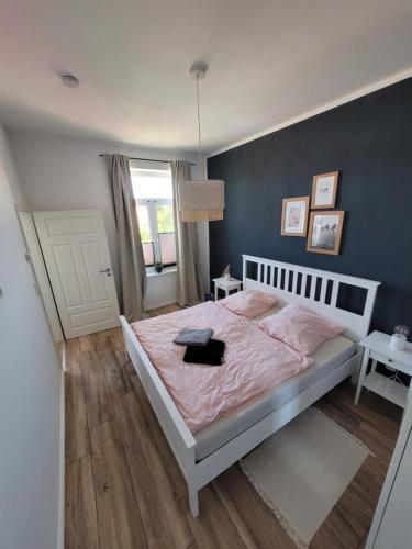 a bedroom with a bed with a pink comforter at Apartment mit beach flair in Garz-Rügen