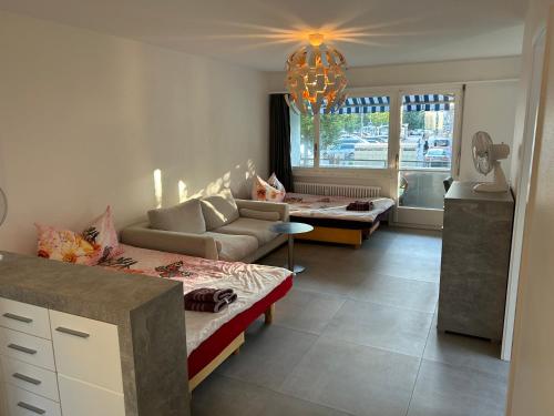 een woonkamer met 2 bedden en een bank bij HANNA Apartment in Interlaken