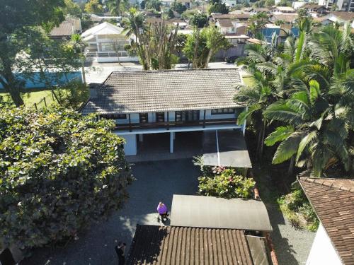 une vue de tête sur une maison avec une personne debout dans une cour dans l'établissement Araújo Residence - Lar Doce Lar, à Joinville