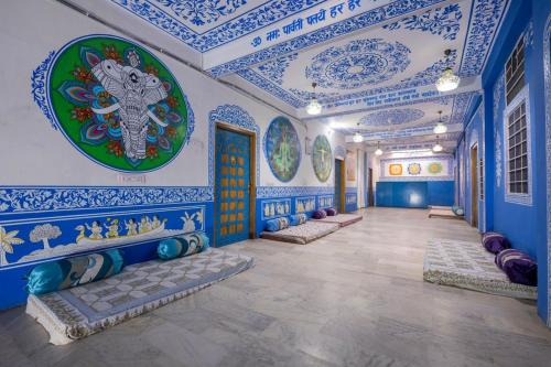 Habitación con paredes azules y blancas y techos azules. en Mandala bagpackers, en Jaipur