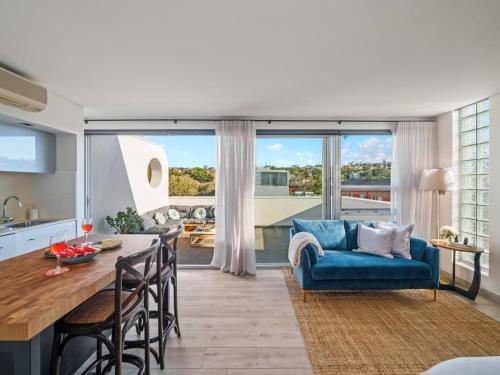 a kitchen and living room with a blue couch at XQ Collection La Casa De Frida - Modern Studio with Balcony in Sydney