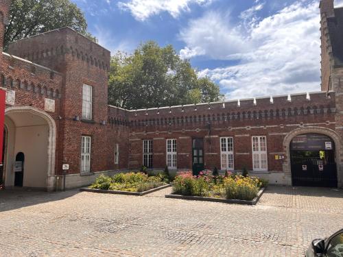 een bakstenen gebouw met bloemen ervoor bij Vakantiewoning De Gulden Sleutels in Kruibeke