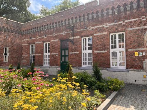 een bakstenen gebouw met bloemen ervoor bij Vakantiewoning De Gulden Sleutels in Kruibeke