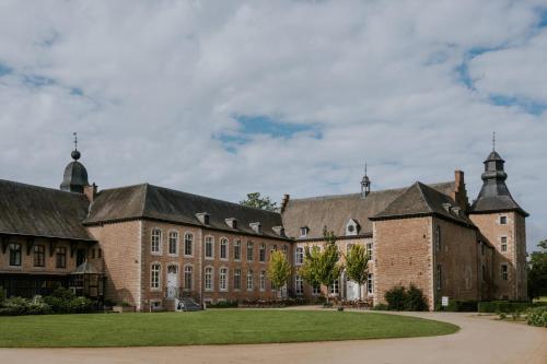 duży ceglany budynek z zielonym trawnikiem w obiekcie Château de Looz w mieście Borgloon