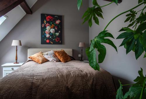 a bedroom with a bed with a painting on the wall at B&B De zilveren reiger in Middelburg