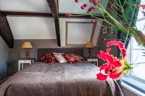 a bedroom with a bed with two tables and a window at B&B De zilveren reiger in Middelburg