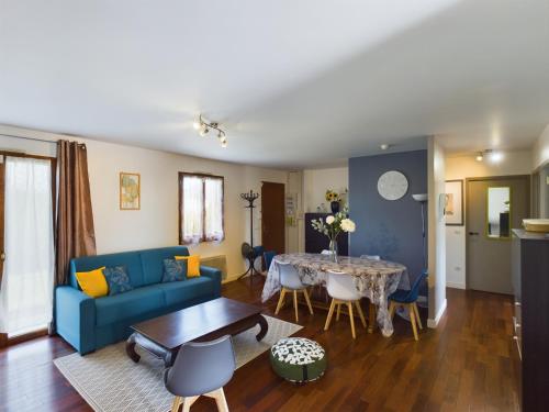 sala de estar con sofá azul y mesa en Maison du Bien-Être, en Romilly-sur-Seine