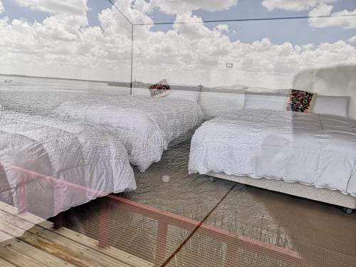 A bed or beds in a room at Uros Suma Qhota Lodge