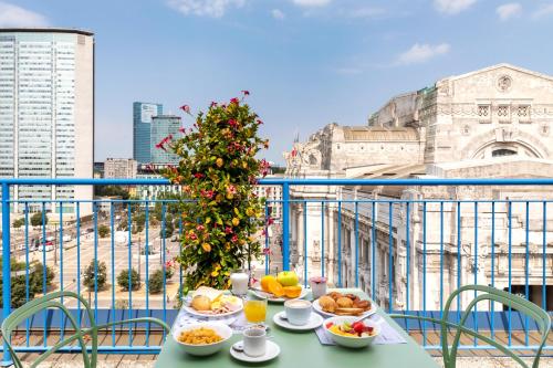 a table with plates of food on a balcony at B&B Hotel Milano Aosta in Milan