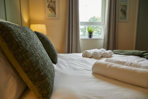 een bed met twee handdoeken en een raam bij Stylish 2-Bedroom Apartment with Free Parking in Halifax