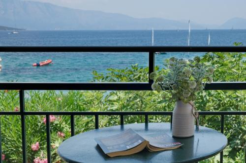 un tavolo con un vaso e libri su un balcone con vista sull'oceano di S7 apartment a Nikiana