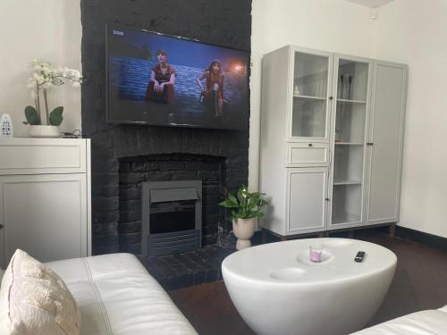 a living room with a tv and a fireplace at Slick Space for a Standish Stay in Standish