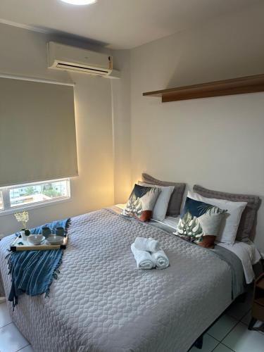 een slaapkamer met een groot bed en handdoeken bij Studio 1131 - Extraordinário in Ribeirão Preto