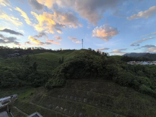 una vista de una colina de hierba con un cielo nublado en Cómodo, nuevo y con linda vista., en Manizales