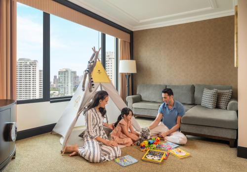 uma família sentada numa sala de estar com uma tenda de jogos em Sheraton Grande Sukhumvit, a Luxury Collection Hotel, Bangkok em Banguecoque