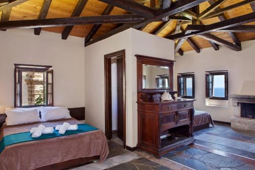 - une chambre avec un lit, une commode et un miroir dans l'établissement Byzantino Boutique Hotel, à Monemvasia