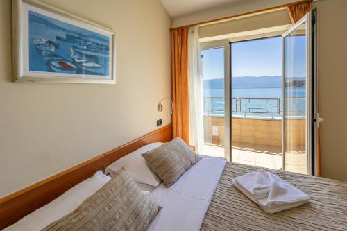 una camera con letto e vista sull'oceano di Hotel Dobrovit a Baška