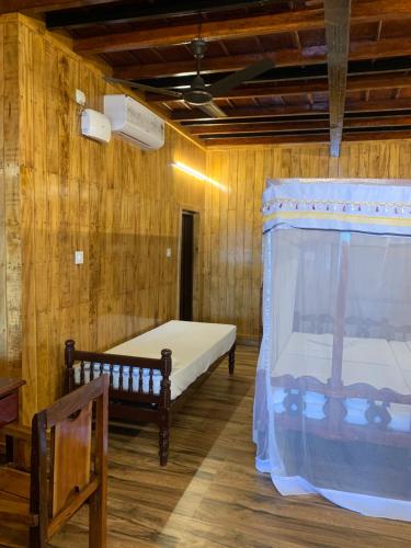 a bedroom with two beds in a wooden room at Malayalam Lake Resort in Alleppey