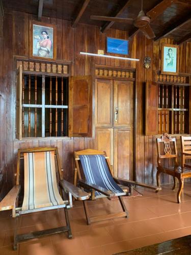 two chairs in a room with wooden walls at Malayalam Lake Resort in Alleppey