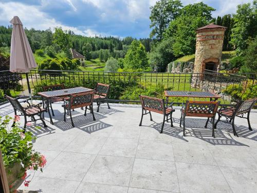 een patio met tafels en stoelen en een parasol bij Bille in Bille