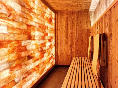 een sauna met een bank en een bakstenen muur bij Post-Hotel in Mittenwald