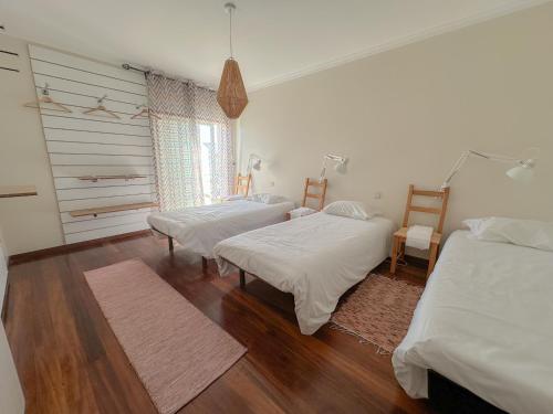 Duas camas num quarto com pisos em madeira em Hello Esposende em Esposende