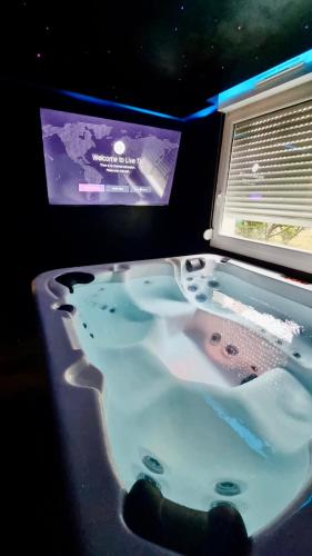 ストラスブールにあるCosy family spa Strasbourg centerのバスタブ、テレビ(客室内)