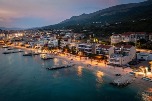 una vista aerea di una spiaggia in una città di notte di Seaside Luxury Suites a Podstrana