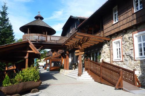 een gebouw met een houten loopbrug ervoor bij Hotel Sepetná - Silvestr s polopenzí, animačním programem a silvestrovskou párty! in Ostravice