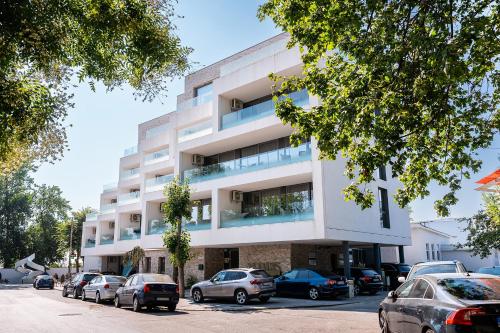 un edificio bianco con macchine parcheggiate di fronte di AMARIS a Eforie Nord