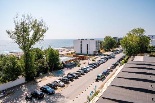 una strada con un sacco di auto parcheggiate vicino all'oceano di AMARIS a Eforie Nord