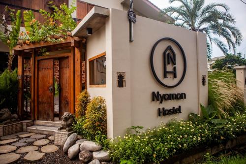 un cartello per un hotel Morgan di fronte a un edificio di Nyaman Hostel a Canggu