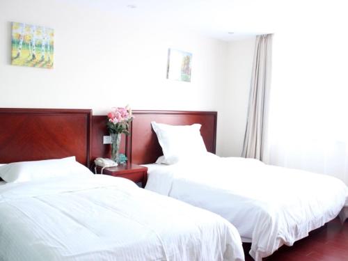 duas camas num quarto com lençóis brancos em GreenTree Inn Guangdong Foshan Longjiang North Fenghua Road Express Hotel em Shunde