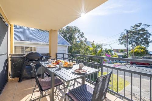 a table on a balcony with food on it at Starfish Lodge, 2-1a Messines St - pet friendly, air con and Wi-Fi in Shoal Bay