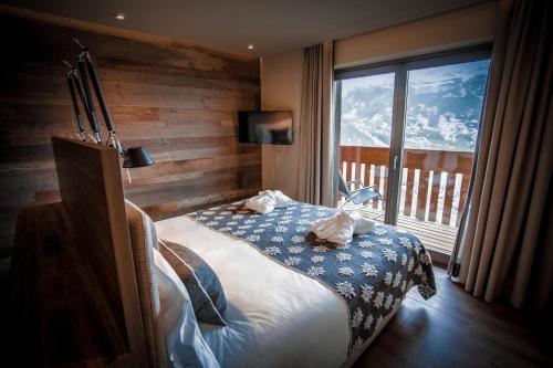 een slaapkamer met een bed en een groot raam bij La Cresta Chalet in Breuil-Cervinia