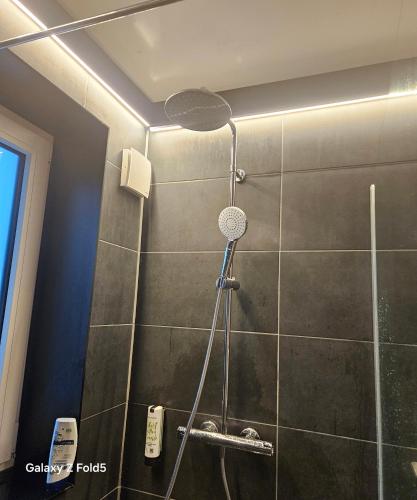 La salle de bains est pourvue d'une douche avec un pommeau de douche. dans l'établissement HBR HÔTEL By HÔTEL, à Balma