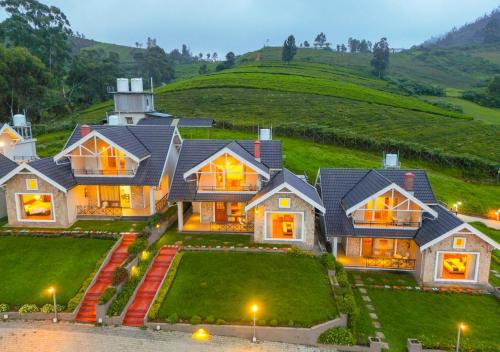 een groot huis met een heuvel op de achtergrond bij AJ Gable Clouds Ooty by VOYE HOMES - Serene Stay Near Avalanche Emerald Lake in Ooty