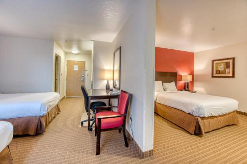 um quarto de hotel com duas camas e uma secretária em Inn America - Boise em Boise