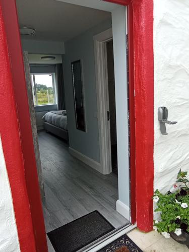 - une porte rouge menant à une chambre dans l'établissement Tiernan's Luxury Cottages, à Charlestown