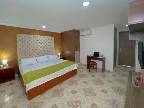 una camera d'albergo con letto e scrivania di Hotel Prado 72 INN a Barranquilla