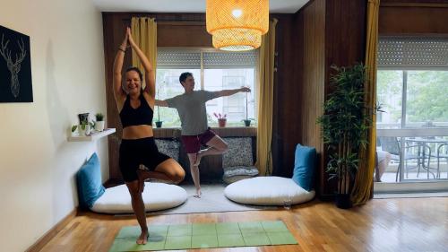 zwei Frauen in einem Yoga-Kurs im Wohnzimmer in der Unterkunft Origami Porto Residência & Hostel in Vila Nova de Gaia