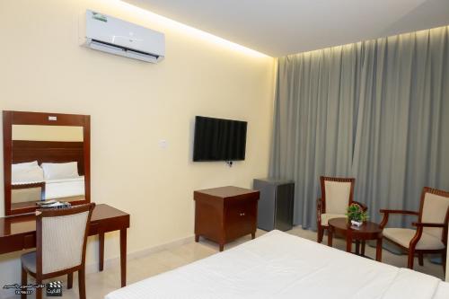 a hotel room with a bed and a tv at Al Jabal Hotel in Salalah