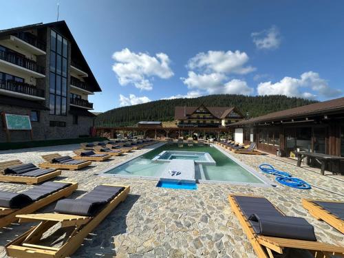 un resort con piscina e sedie a sdraio di Poarta Raiului a Tău Bistra