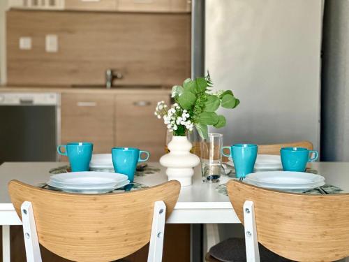 a dining room table with blue dishes and a vase with flowers at Apartamenty A&M in Stargard